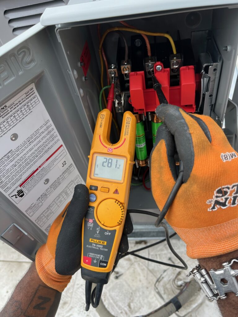 Multimeter testing a circuit inside an electrical panel