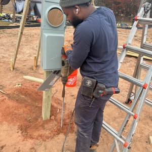 Electrician working on an exterior meter base and service equipment